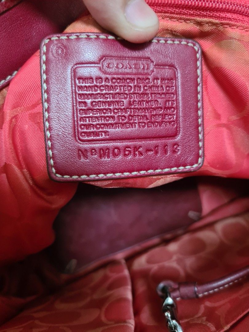 Coach Straw and Red Leather Handbag (Category: Luxury Bags & Wallets) located in Manila. Submitted by sevyaleinad (Listing ID 1465777382, Image 2). Description: - Brand: Coach - Material: Straw weave with dark red leather trim - Interior: Vibrant pink fabric lining with signature C pattern - Compartments: Front pocket with buckle detail, interior zipper, and slip pockets - Closure: Top zipper with dual handles - Authenticity: Serial number stamp 