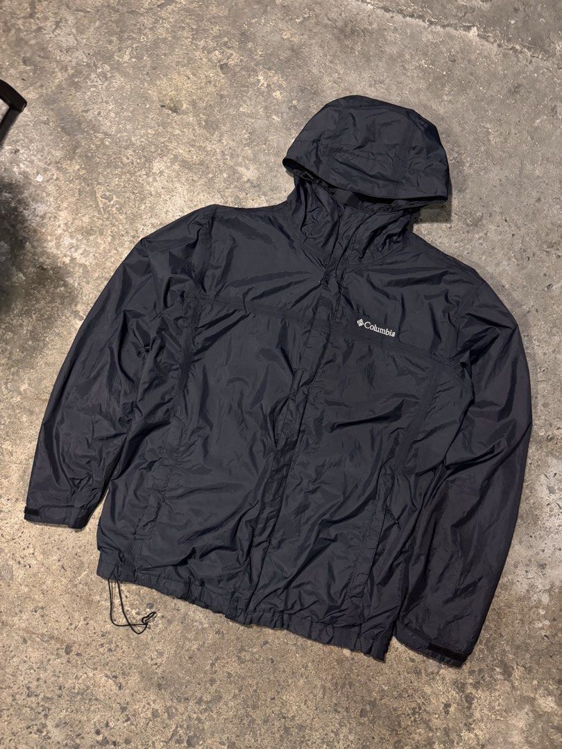 Columbia Black Hooded Windbreaker Jacket (Category: Coats, Jackets and Outerwear) located in Pasig City. Submitted by dripthrift1600 (Listing ID 1465950037, Image 1). Description: - Brand: Columbia - Color: Classic Black - Size: Check measurements (DM for exact fit) - Material: Lightweight, packable nylon with breathable mesh lining - Features: Attached hood, full zip closure with Velcro storm flap, adjustable drawstrings at hood and bottom hem -