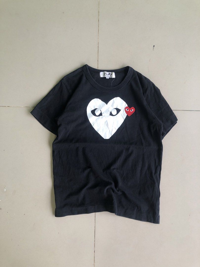 COMME des GARÇONS PLAY Black Heart Tee Size M (Category: Activewear) located in Cagayan de Oro. Submitted by leklekthrift (Listing ID 1465891611, Image 1). Description: - Brand: COMME des GARÇONS PLAY - Item: Black T-Shirt - Size: Medium - Material: 100% Cotton (Made in Japan) - Design: Large white heart chest print with black eyes and signature red embroidered heart badge - Condition: Interior neck and care labels intact; minor wrinkles on the l