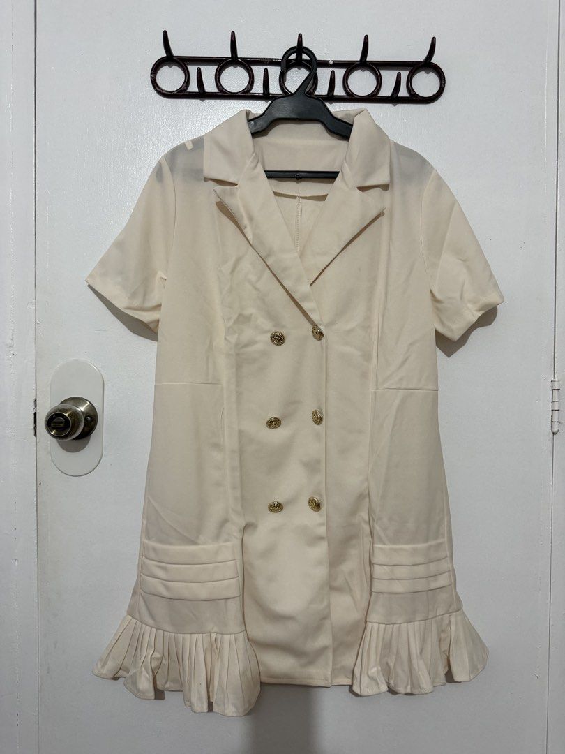 Cream Double-Breasted Blazer Dress with Chain Strap (Category: Dresses) located in Las Pinas. Submitted by milkydeclutter (Listing ID 1465940179, Image 1). Description: - Color: Cream - Style: Double-breasted blazer dress with lapel collar and short sleeves - Accents: Gold-toned buttons, pleated ruffle hem, and pleated pocket details - Accessory: Includes a chic gold and black interwoven chain belt - Fabric: Smooth finish for a polished look - Co