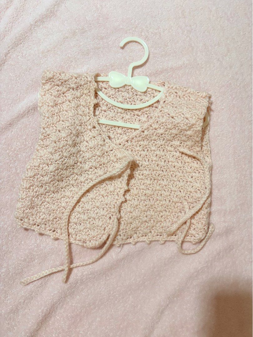 crochet baby wrap top (Category: Babies & Kids Fashion) located in Quezon City. Submitted by closettreasure123 (Listing ID 1465264957, Image 2). Description: 12-18 months featuring a textured shell or seed stitch pattern in a soft pink hue. It is styled with adjustable side-tie closures.