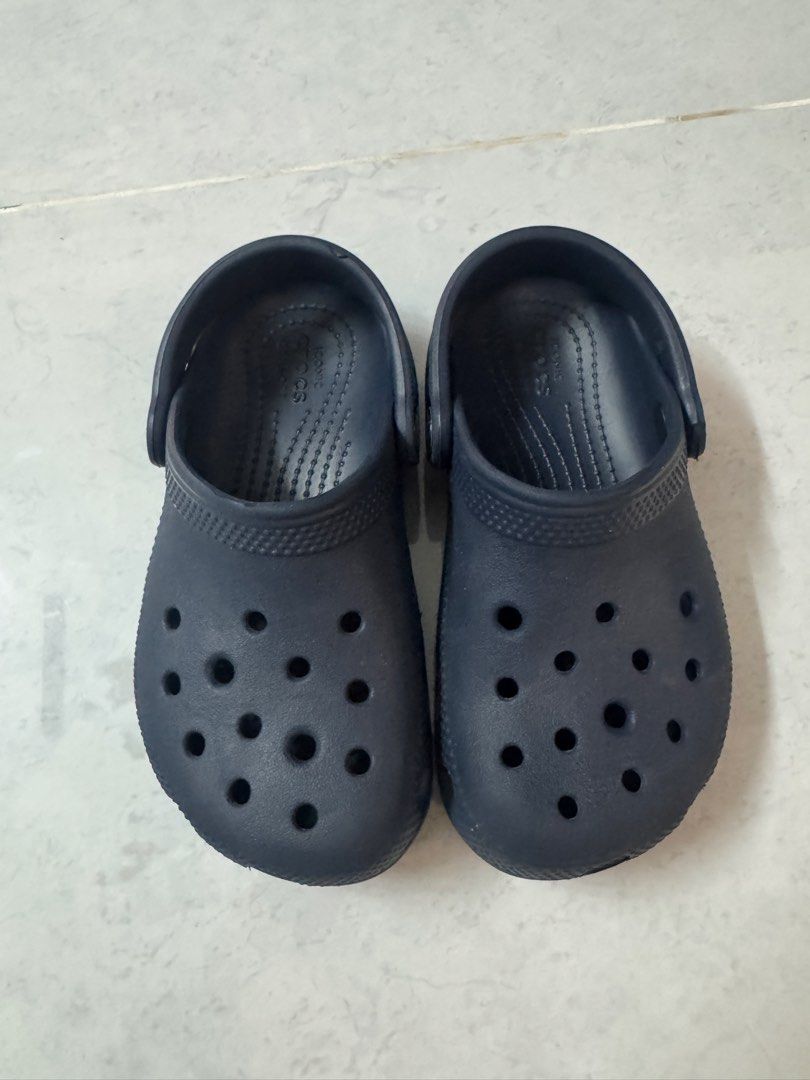 Crocs Classic Navy Blue Clogs Size 10 (Legit crocs) (Category: Babies & Kids Fashion) located in Binan City. Submitted by dupie_warren1982 (Listing ID 1465850278, Image 3). Description: - Color: Classic Navy Blue - Size: Toddlers US 10 (Stamped on sole) - Comfort: Iconic Crocs comfort footbed with ventilation holes for breathability - Fit: Secure pivoting heel straps with classic logo buttons - Condition: Great slip-on shoes for casual wear, walk