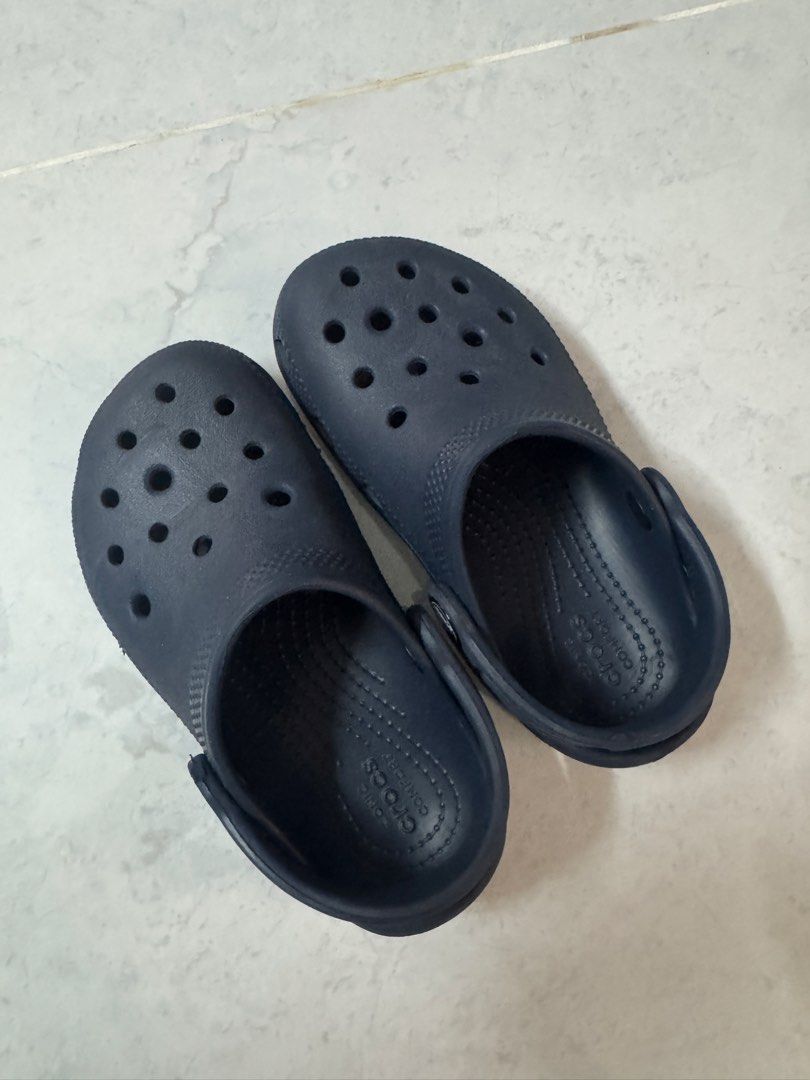 Crocs Classic Navy Blue Clogs Size 10 (Legit crocs) (Category: Babies & Kids Fashion) located in Binan City. Submitted by dupie_warren1982 (Listing ID 1465850278, Image 1). Description: - Color: Classic Navy Blue - Size: Toddlers US 10 (Stamped on sole) - Comfort: Iconic Crocs comfort footbed with ventilation holes for breathability - Fit: Secure pivoting heel straps with classic logo buttons - Condition: Great slip-on shoes for casual wear, walk