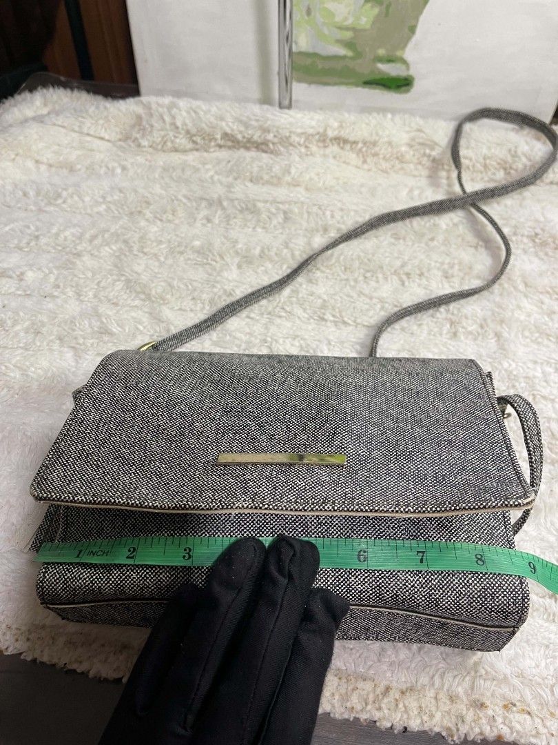 Crossbody Bag with Tassel (Category: Cross-body Bags) located in Naawan. Submitted by twilly.apparel2 (Listing ID 1465845300, Image 3). Description: - Material/Design: Black and white textured tweed with a metal bar accent on the flap top - Accessories: Includes a removable beige tassel charm - Strap: Long, adjustable shoulder strap for comfortable wear - Size: Measures approximately 8 inches across - Condition: Good overall condition with a mino