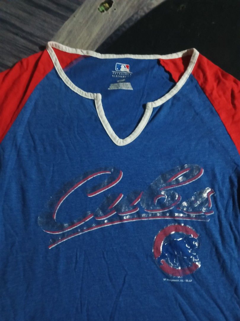 CUBS (Category: Blouses) located in Manila. Submitted by icamalicdem29 (Listing ID 1465951145, Image 3). Description: The image shows a blue and red Chicago Cubs MLB V-neck baseball t-shirt with short raglan sleeves and white striped trim.