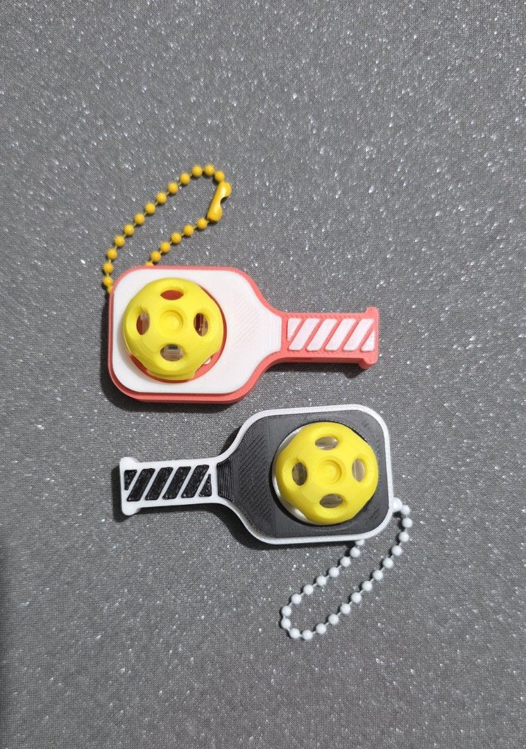 Custom 3D Pickleball Paddle Clicker and Whistle charm (Category: Racket and Ball Sports) located in Quezon City. Submitted by cottoncandyqc (Listing ID 1465919514, Image 2). Description: - Fun 3D-printed miniature pickleball paddle keychain featuring a clicker mini ball - also functions as a whistle - Customizable with names/text (add 20p) (3-7 days for bulk orders) - Multi-color sturdy but lightweight PLA with optional silver keychain - Durable 
