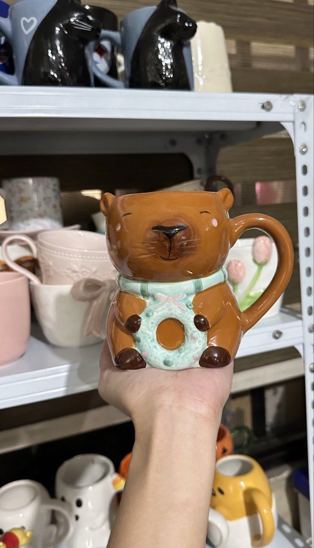 Cute bear ceramic mug with pastel green scarf (Category: Coffee & Tea Tableware) located in Manila. Submitted by tinayyy_08 (Listing ID 1465932139, Image 1). Description: - Adorable brown bear ceramic mug featuring a pastel green donut or wreath - Hand-painted facial details with charming rosy cheeks and whiskers - High-gloss finish with a sturdy handle for a comfortable grip - Great addition to your daily coffee routine or cute mug collection - 