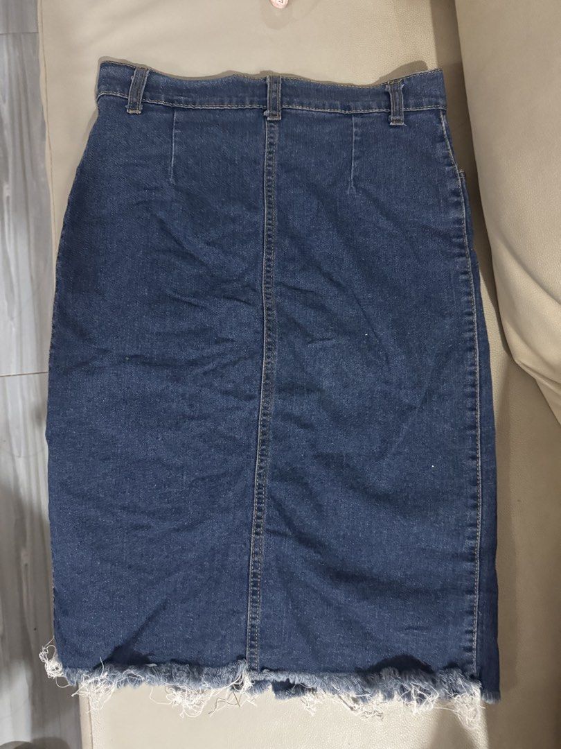 Dark Blue Denim Skirt with Button-Down Front and Raw Hem (Category: Skirts) located in Angeles City. Submitted by thala.1204.68 (Listing ID 1465805543, Image 2). Description: - Color: Dark blue denim Waist size -25-26 (stretchable) - Fit: Classic high-waisted cut - Details: Functional metal front buttons, side pockets, and trendy raw frayed hem - Length: Approx. 21 to 22 inches from waist to hem - Styling: Versatile piece that pairs easily with t