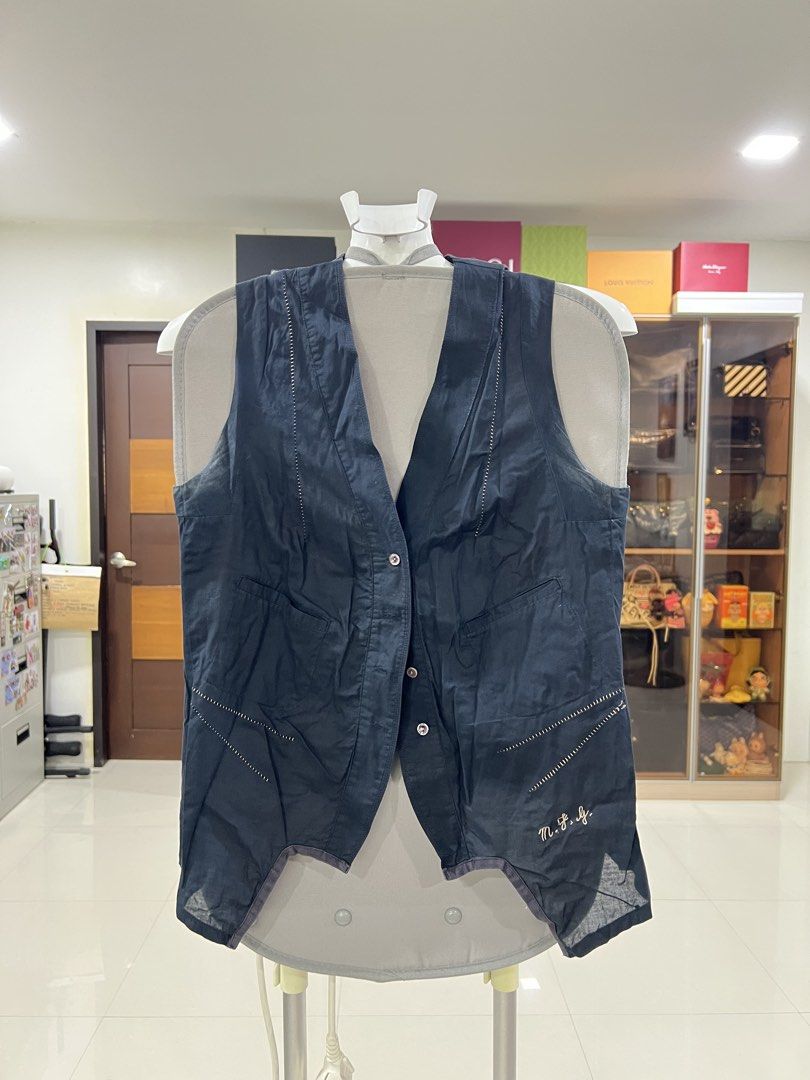 Dark Blue Sleeveless Vest with Front Buttons (Category: Sleeveless) located in Manila. Submitted by imprincessg888 (Listing ID 1465848281, Image 1). Description: - Color: Dark blue - Closure: Button-up front with 3 buttons - Pockets: Two front pockets near the hem - Design: Decorative white stitching and small cursive embroidery - Fit: Lightweight fabric with an asymmetrical cut hem - Condition: Excellent, pre-loved from a trusted Carousell selle