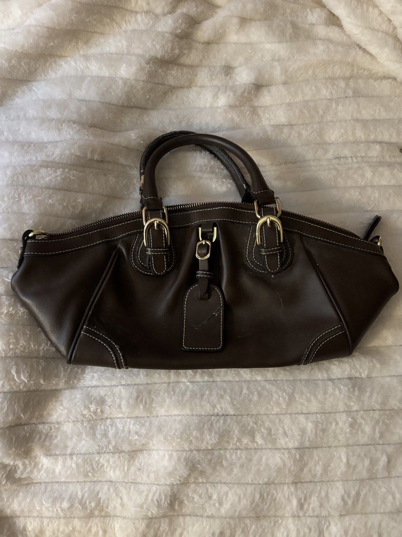 Dark Brown Leather Handbag with Gold Hardware (Category: Luxury Bags & Wallets) located in Quezon City. Submitted by hadescloset (Listing ID 1465762928, Image 1). Description: - Color: Dark brown with white contrast stitching - Hardware: Gold-tone buckles and zippers - Interior: Grey and white chevron pattern lining with one zip pocket and one slip pocket - Closure: Secure zip-around top - Handles: Dual top handles with a chic hanging leather lug