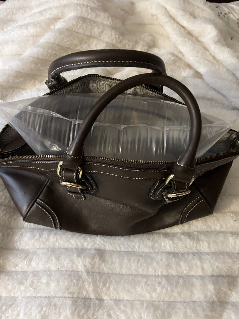 Dark Brown Leather Handbag with Gold Hardware (Category: Luxury Bags & Wallets) located in Quezon City. Submitted by hadescloset (Listing ID 1465762928, Image 2). Description: - Color: Dark brown with white contrast stitching - Hardware: Gold-tone buckles and zippers - Interior: Grey and white chevron pattern lining with one zip pocket and one slip pocket - Closure: Secure zip-around top - Handles: Dual top handles with a chic hanging leather lug