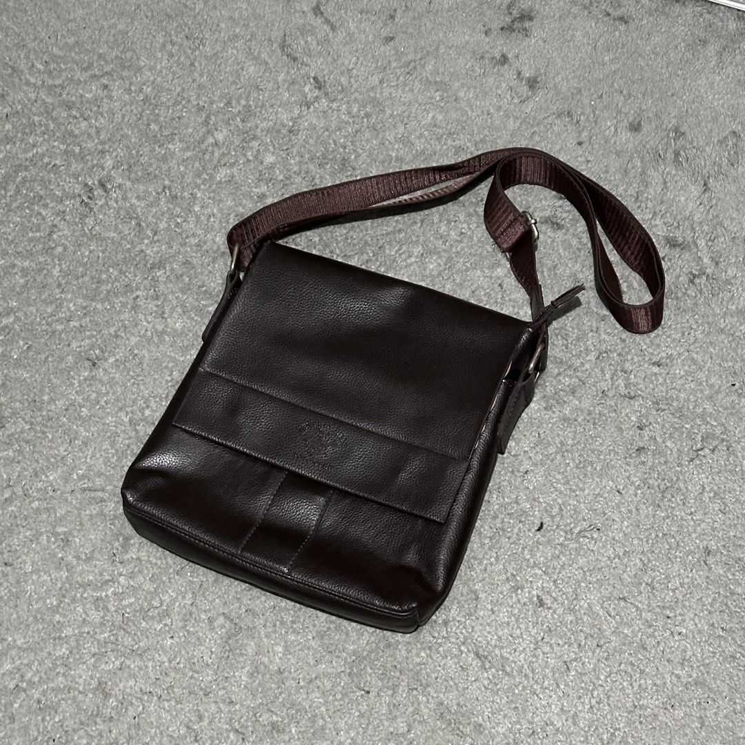 Dark Brown Leather Messenger Bag Crossbody (Category: Sling Bags) located in Lipa City. Submitted by jecoparra (Listing ID 1465843700, Image 2). Description: - Color: Dark brown - Material: Clean pebble texture faux leather - Closure: Flap closure - Strap: Adjustable brown fabric shoulder strap - Storage: Convenient exterior back zipper pocket + roomy main compartment for a tablet, wallet, and keys - Use: Perfect for daily commuting and casual us