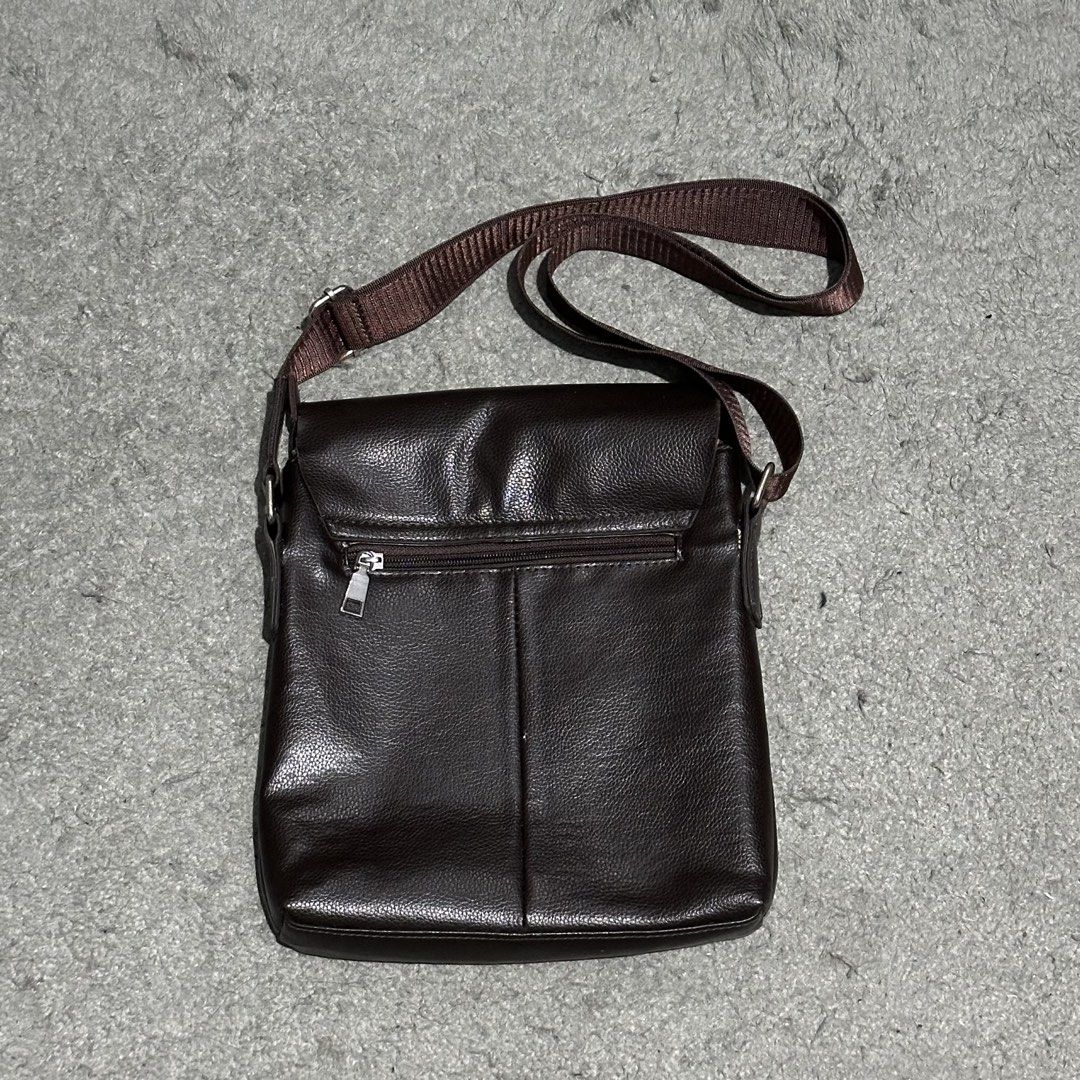 Dark Brown Leather Messenger Bag Crossbody (Category: Sling Bags) located in Lipa City. Submitted by jecoparra (Listing ID 1465843700, Image 3). Description: - Color: Dark brown - Material: Clean pebble texture faux leather - Closure: Flap closure - Strap: Adjustable brown fabric shoulder strap - Storage: Convenient exterior back zipper pocket + roomy main compartment for a tablet, wallet, and keys - Use: Perfect for daily commuting and casual us