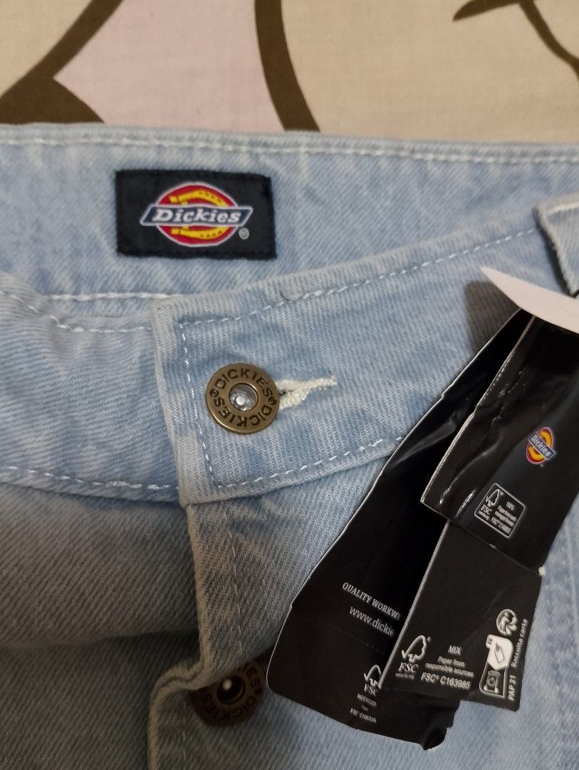 Dickies Light Blue Denim Button-Front Skirt (Category: Skirts) located in Adams. Submitted by swiftrabbit (Listing ID 1465936701, Image 2). Description: - Brand: Dickies - Color: Light blue denim - Condition: Brand new with original retail tags attached - Closure: Front button closure with branded metal hardware - Pockets: Convenient front patch pockets - Details: Belt loops at the waistband and small logo patch on the lower right side.