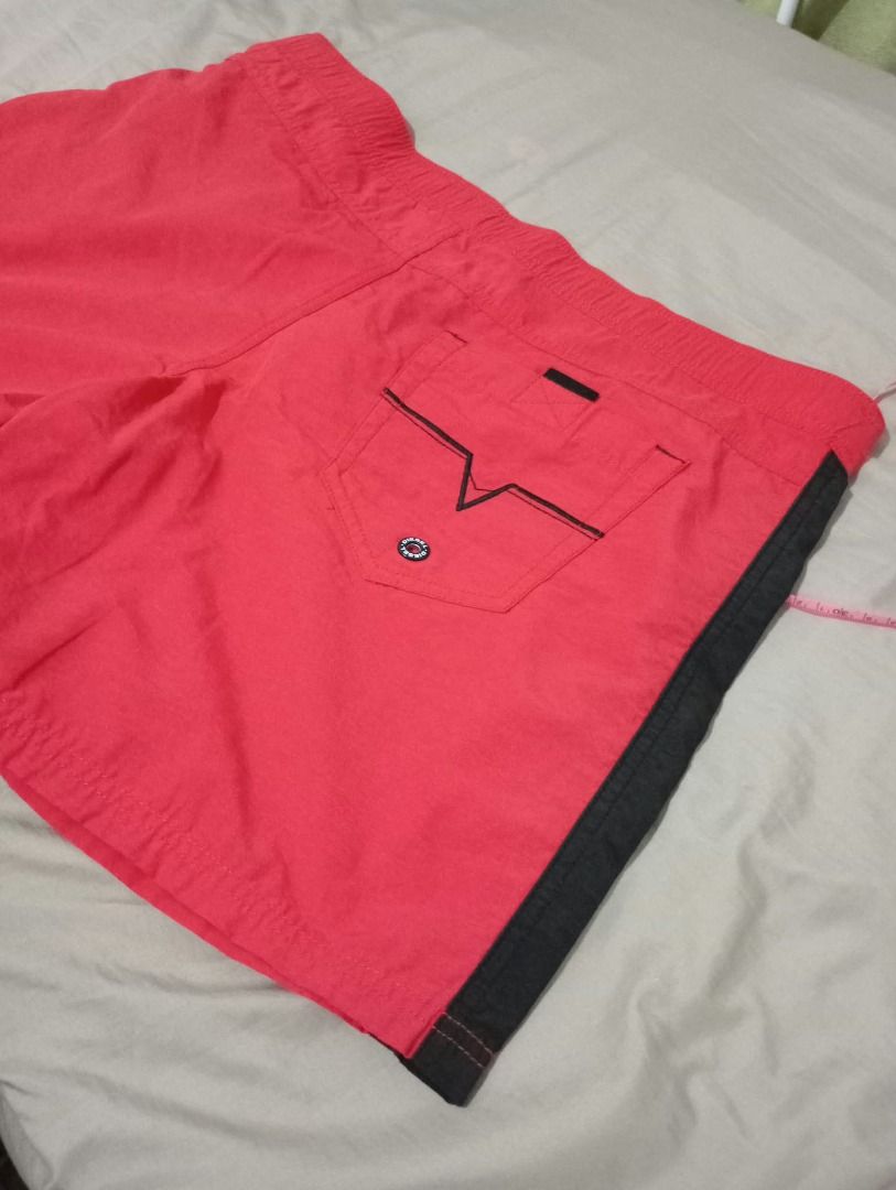 Diesel Red Swim Shorts (Men) (Category: Shorts) located in Pasig City. Submitted by ajms63804 (Listing ID 1465783180, Image 3). Description: - Brand: Diesel - Size: Fits 36" to 38'" - Color: Red with black side panels - Details: Graphic logo print on lower left leg - Pocket: Single back pocket with button closure - Fit: Comfortable for beach days or casual wear - Sizing: Waistband measurement shown in photos.