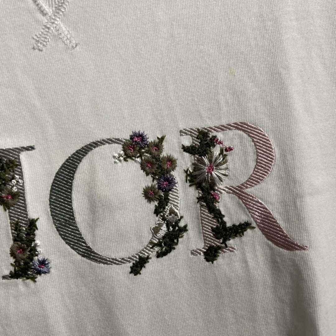 Dior Flower (Category: Luxury Apparel) located in Manila. Submitted by lumang__gamit00 (Listing ID 1465802629, Image 3). Description: The white cotton tee features a distinctive "DIOR" chest logo filled with colorful floral embroidery 20-29 no issue.