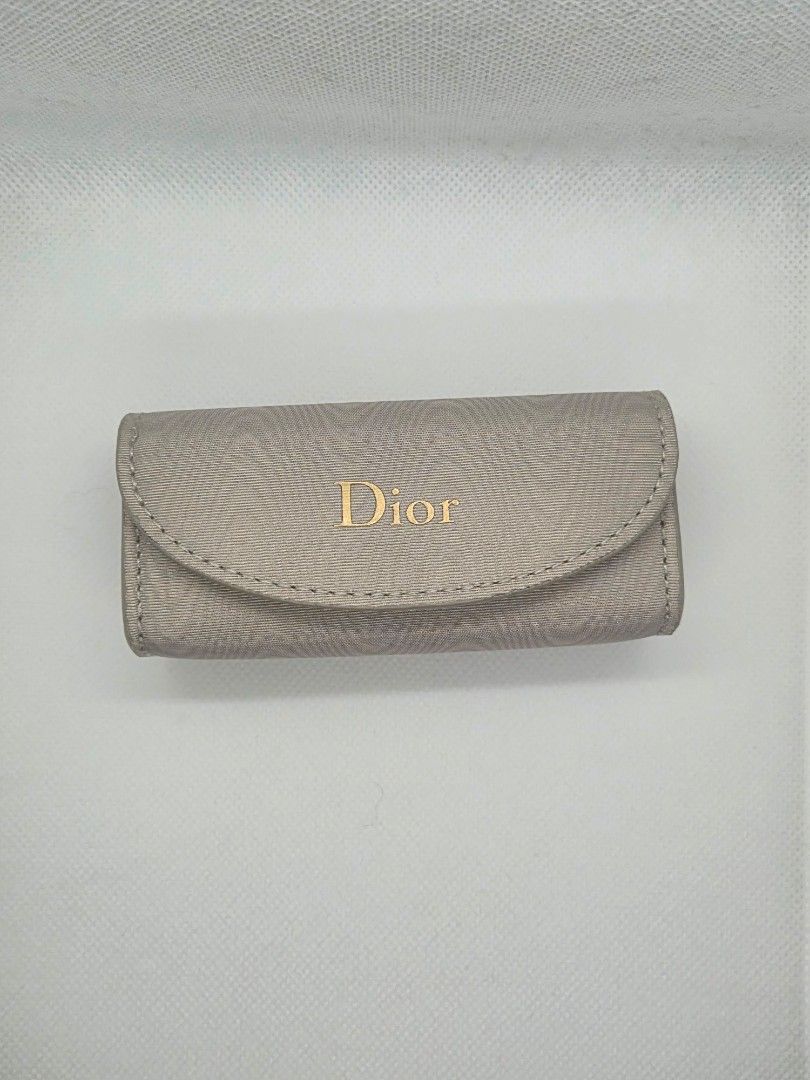 Dior Grey Fabric Jewelry Case (Category: Accessory Holder, Box & Organizers) located in Manila. Submitted by prelovedbyc.hannah (Listing ID 1465849509, Image 1). Description: - Brand: Dior - Material: Grey textured fabric with clean white interior lining - Accents: Signature gold Dior logo on front flap - Closure: Secure magnetic snap - Storage: Padded rolls designed to hold multiple rings securely - Size: Approximately 12 cm long - Condition: Ex
