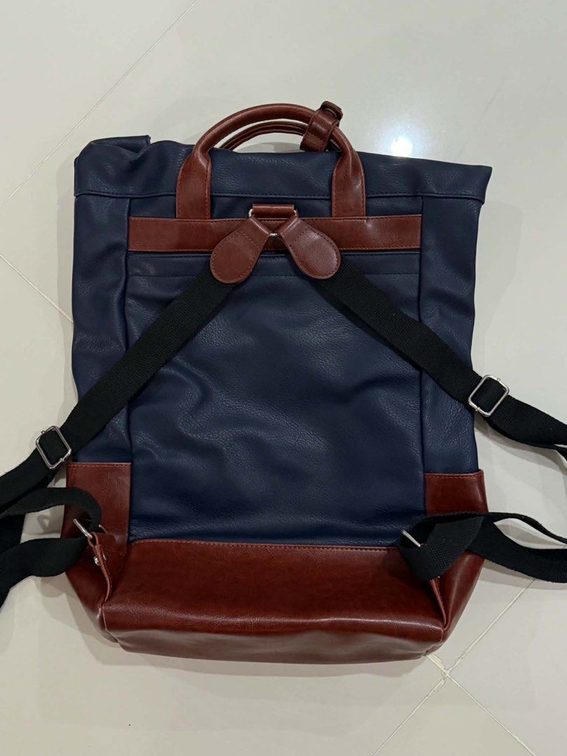 d.kelly 1985 Navy and Brown Backpack (Category: Backpacks) located in Cabuyao City. Submitted by seokjinspree (Listing ID 1465761895, Image 2). Description: Brand: D.Kelly 1985 Color: Navy blue with stylish brown faux leather trim Carry Options: Dual top carry handles and adjustable black shoulder straps Storage: Front zipper pocket and a spacious main compartment Details: Metallic brand plaque and embossed lettering on the lower front.