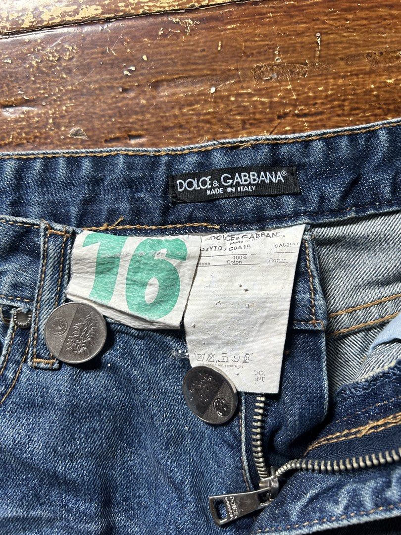 Dolce & Gabbana Denim Shorts (Category: Shorts) located in Manila. Submitted by mystic_mikki (Listing ID 1465910020, Image 3). Description: - Brand: Dolce & Gabbana - Style: Distressed blue denim shorts with raw frayed hems - Details: Red & white plaid fabric patches on back pocket and interior cuffs, plus branded metal plaque on rear - Material: 100% Cotton, Made in Italy - Closure: Button fly - Condition: Excellent / Well-maintained - Mode of P