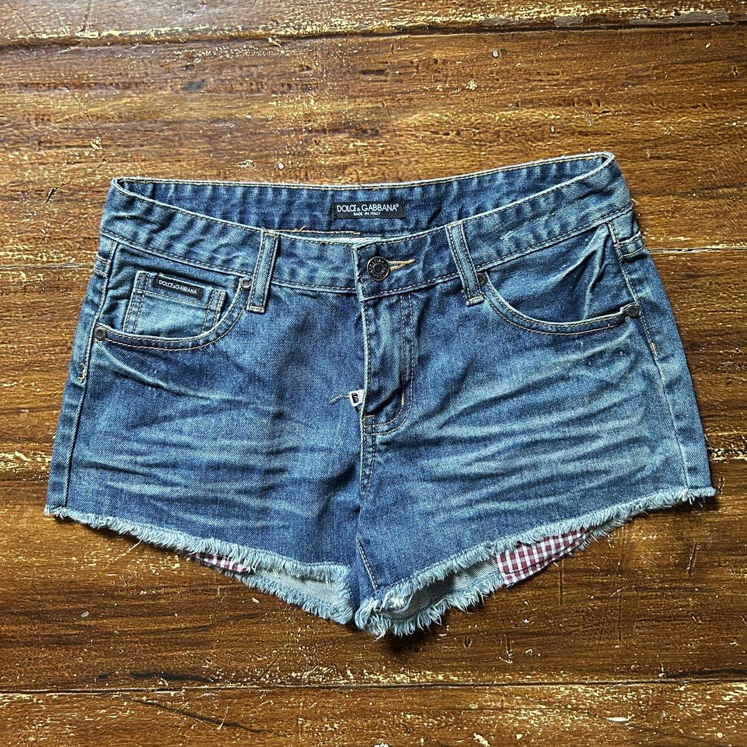 Dolce & Gabbana Denim Shorts (Category: Shorts) located in Manila. Submitted by mystic_mikki (Listing ID 1465910020, Image 1). Description: - Brand: Dolce & Gabbana - Style: Distressed blue denim shorts with raw frayed hems - Details: Red & white plaid fabric patches on back pocket and interior cuffs, plus branded metal plaque on rear - Material: 100% Cotton, Made in Italy - Closure: Button fly - Condition: Excellent / Well-maintained - Mode of P