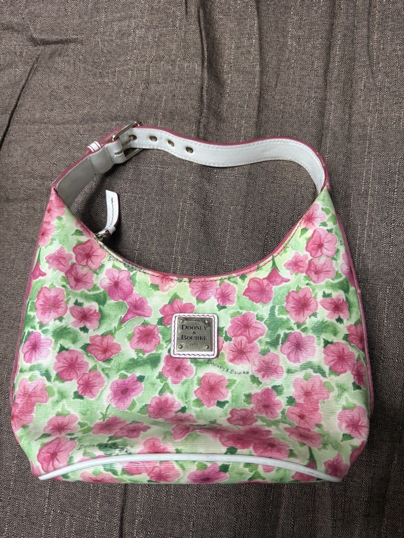 Dooney & Bourke Floral Shoulder Bag (Category: Luxury Bags & Wallets) located in Quezon City. Submitted by mt031199 (Listing ID 1465947068, Image 2). Description: - Brand: Dooney & Bourke - Style: Shoulder Bag - Exterior: Pink and green floral print canvas with white leather trim - Hardware: Silver-tone metal logo plaque - Interior: Bright red fabric lining with slip pockets and a zip pocket - Closure: Top zipper closure - Strap: Adjustable white