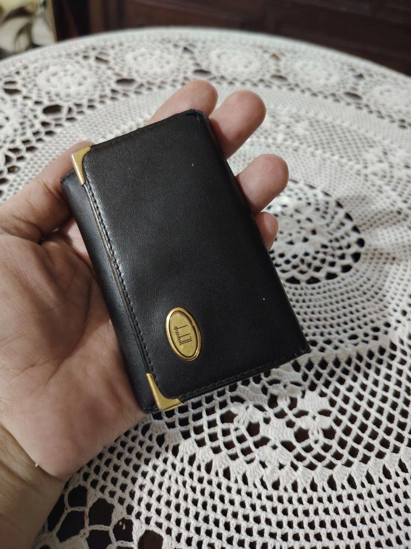 Dunhill Black Leather Key Holder Case (Category: Wallets & Card Holders) located in Luisiana. Submitted by sahayamay77 (Listing ID 1465819491, Image 2). Description: - Authentic Dunhill key holder made in Spain - Premium black genuine calfskin leather - Elegant gold-tone hardware and corner accents - Interior features gold logo branding and multiple key hooks - Secure snap button closure - Compact size, perfect for pockets or bags - Condition: as