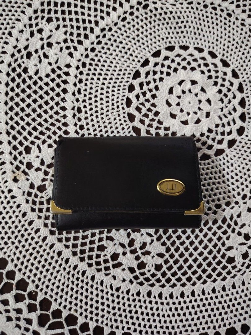 Dunhill Black Leather Key Holder Case (Category: Wallets & Card Holders) located in Luisiana. Submitted by sahayamay77 (Listing ID 1465819491, Image 1). Description: - Authentic Dunhill key holder made in Spain - Premium black genuine calfskin leather - Elegant gold-tone hardware and corner accents - Interior features gold logo branding and multiple key hooks - Secure snap button closure - Compact size, perfect for pockets or bags - Condition: as