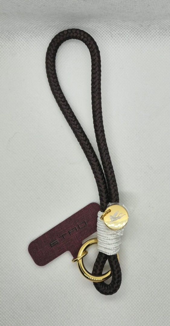 Etro leather phone strap (Category: Other Mobile & Gadget Accessories) located in Manila. Submitted by prelovedbyc.hannah (Listing ID 1465853477, Image 2). Description: - Authentic Etro brown braided rope keychain - Luxurious gold-tone ring hardware with engraved logo emblem - Unique wrapped white thread detail near the bottom - Features signature burgundy fabric brand tag - Comes complete with original black presentation box with gold foil logo 