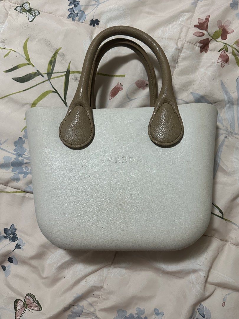 Evreda White Handbag with Brown Handles and Houndstooth Insert (Category: Tote Bags) located in Makati City. Submitted by biancak20 (Listing ID 1465898334, Image 1). Description: - Brand: Evreda - Color: White with brown leather-look handles - Material: Structured rubber body with clean interior lining - Features: Includes a removable black and white houndstooth zippered inner pouch - Size: Handy and compact for daily essentials - Condition: Exce