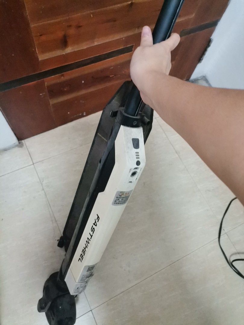 Fastwheel Electric Scooter (Category: Skates, Rollerblades & Scooters) located in Makati City. Submitted by kookybearsstuff (Listing ID 1465801849, Image 2). Description: - Brand: Fastwheel - Color: Black and White - Design: Folds down flat for easy carrying and storage - Condition: Used with some dust and normal wear marks from riding - Features: Power button, indicator lights, and charging port conveniently located near the top handle stem - Wh