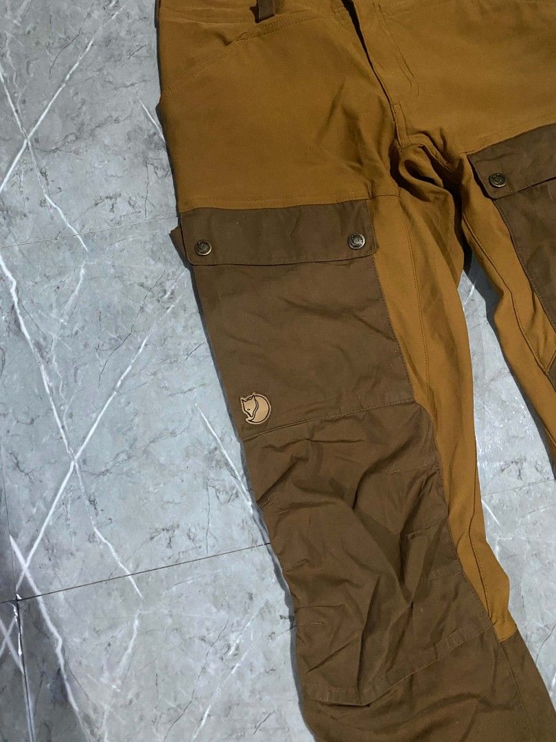 Fjallraven pants (Category: Trousers) located in Polomolok. Submitted by aldrex_18 (Listing ID 1465888146, Image 2). Description: - Brand: Fjallraven - Colorway: Ochre and Autumn Leaf Brown - Material: G-1000 Eco on reinforcement zone - Origin: Made in Vietnam - Features: Ventilation zippers along thighs and calves, adjustable straps at leg endings - Condition: Premium outdoor technical trekking pants size 30.