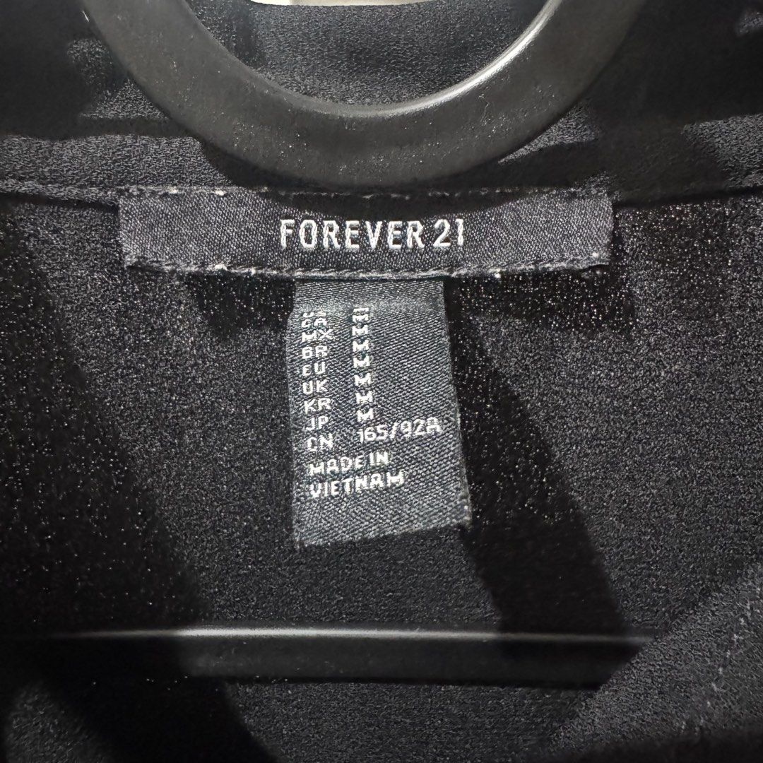 Forever 21 Black Sleeveless Button-Up Blouse (Category: Sleeveless) located in Marikina City. Submitted by preloved_n_reloved (Listing ID 1465912306, Image 2). Description: - Brand: Forever 21 - Color: Classic Black - Size: Medium - Style: Sleeveless button-up with classic collar - Material: Lightweight and breathable fabric - Versatility: Easy to style with jeans, trousers, or skirts - Origin: Made in Vietnam.