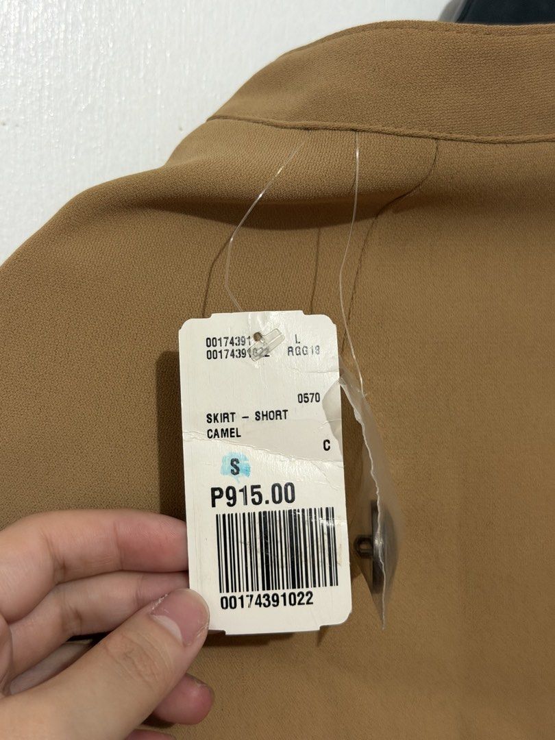 Forever 21 Camel Skirt Size S (Category: Skirts) located in Las Pinas. Submitted by milkydeclutter (Listing ID 1465940373, Image 3). Description: - Brand: Forever 21 - Item: Wrap-design skirt - Color: Camel - Size: Small (S) - Details: Three decorative dark metallic buttons on the side - Closure: Back zipper - Condition: Brand new with original store tags attached.