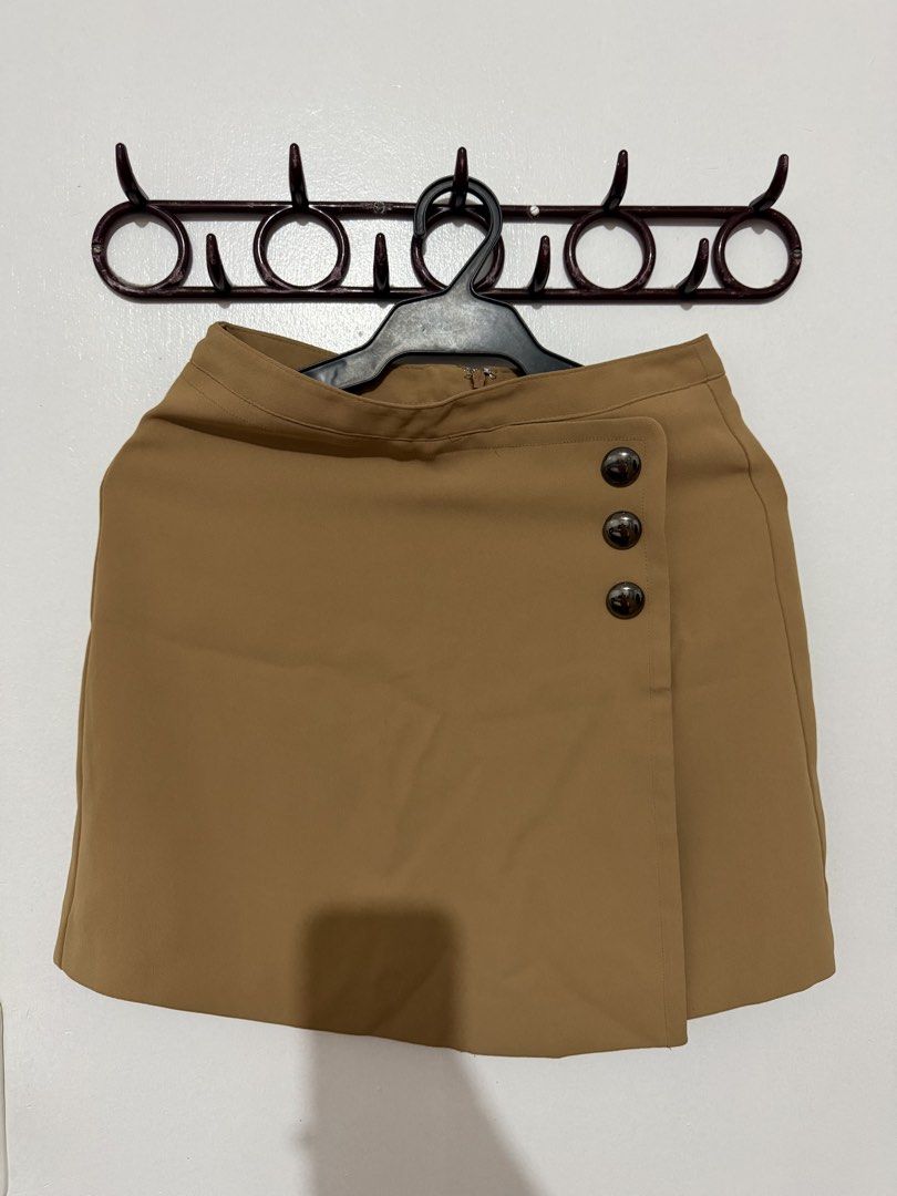 Forever 21 Camel Skirt Size S (Category: Skirts) located in Las Pinas. Submitted by milkydeclutter (Listing ID 1465940373, Image 1). Description: - Brand: Forever 21 - Item: Wrap-design skirt - Color: Camel - Size: Small (S) - Details: Three decorative dark metallic buttons on the side - Closure: Back zipper - Condition: Brand new with original store tags attached.