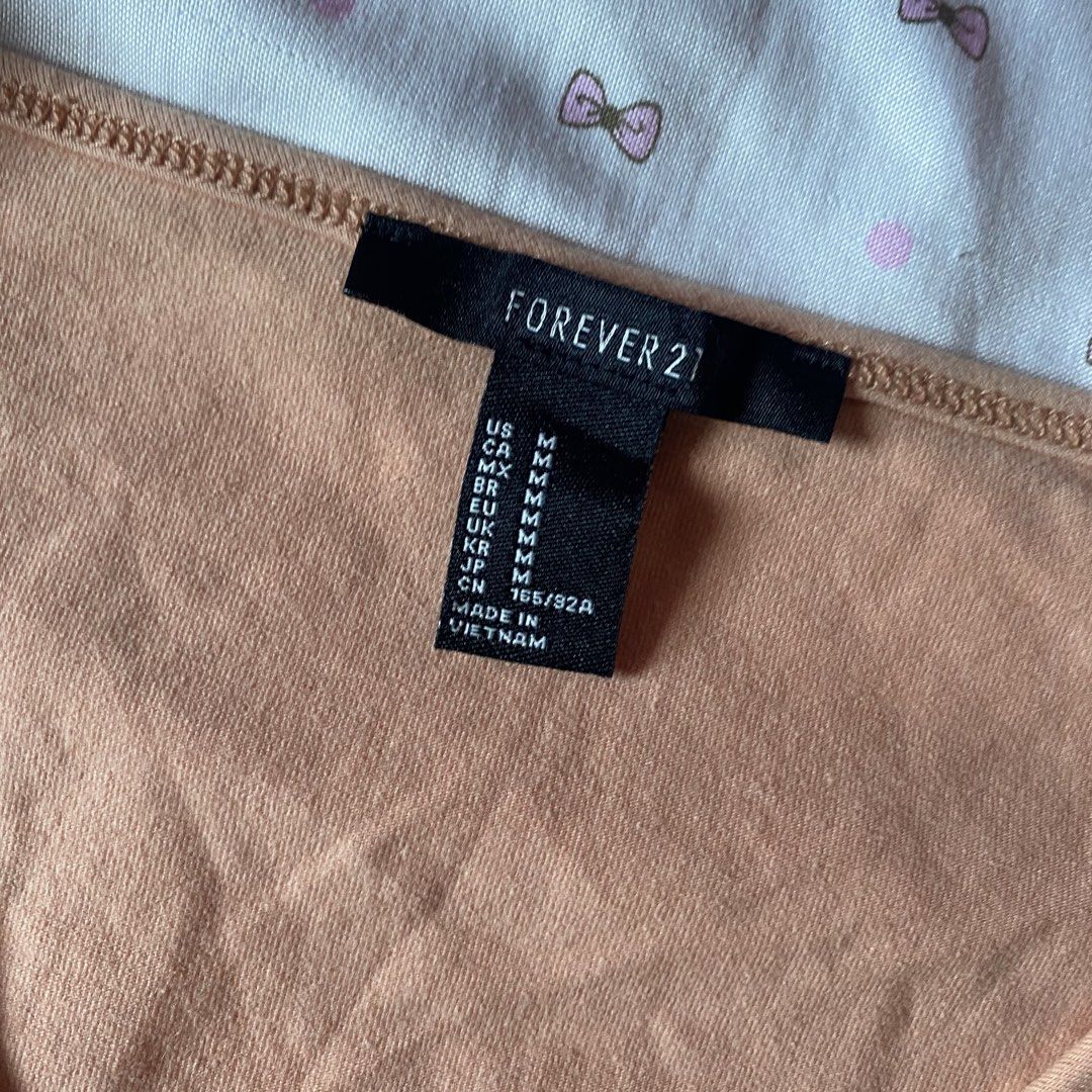 Forever 21 Peach Wrap Crop Top Size M (Category: Sleeveless) located in Abulug. Submitted by dear_darlingdoll (Listing ID 1465846963, Image 3). Description: - Brand: Forever 21 - Size: M - Color: Peach - Material: 95% cotton, 5% spandex (soft and stretchy) - Design: Wrap style, V-neckline, long sleeves, side tie closure - Styling: Perfect to pair with high-waisted jeans or skirts.