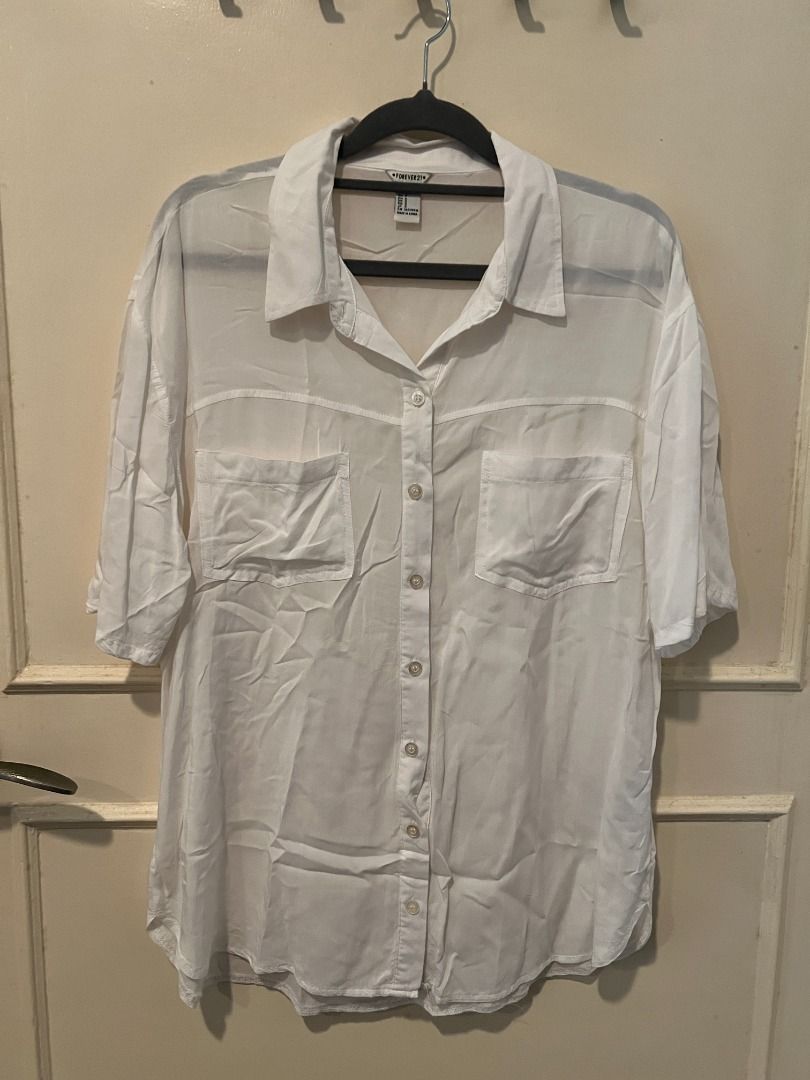 Forever 21 White Button Down Shirt [l3] (Category: Shirts) located in Pasig City. Submitted by awesamfinds (Listing ID 1465851896, Image 1). Description: - Brand/Item: Forever 21 White Button-Down Top - Fit: Relaxed, oversized style - Material: Lightweight, semi-sheer fabric - Features: Short sleeves, pointed collar, front button closure, and two flap chest pockets - Styling: Great versatile piece for layering.