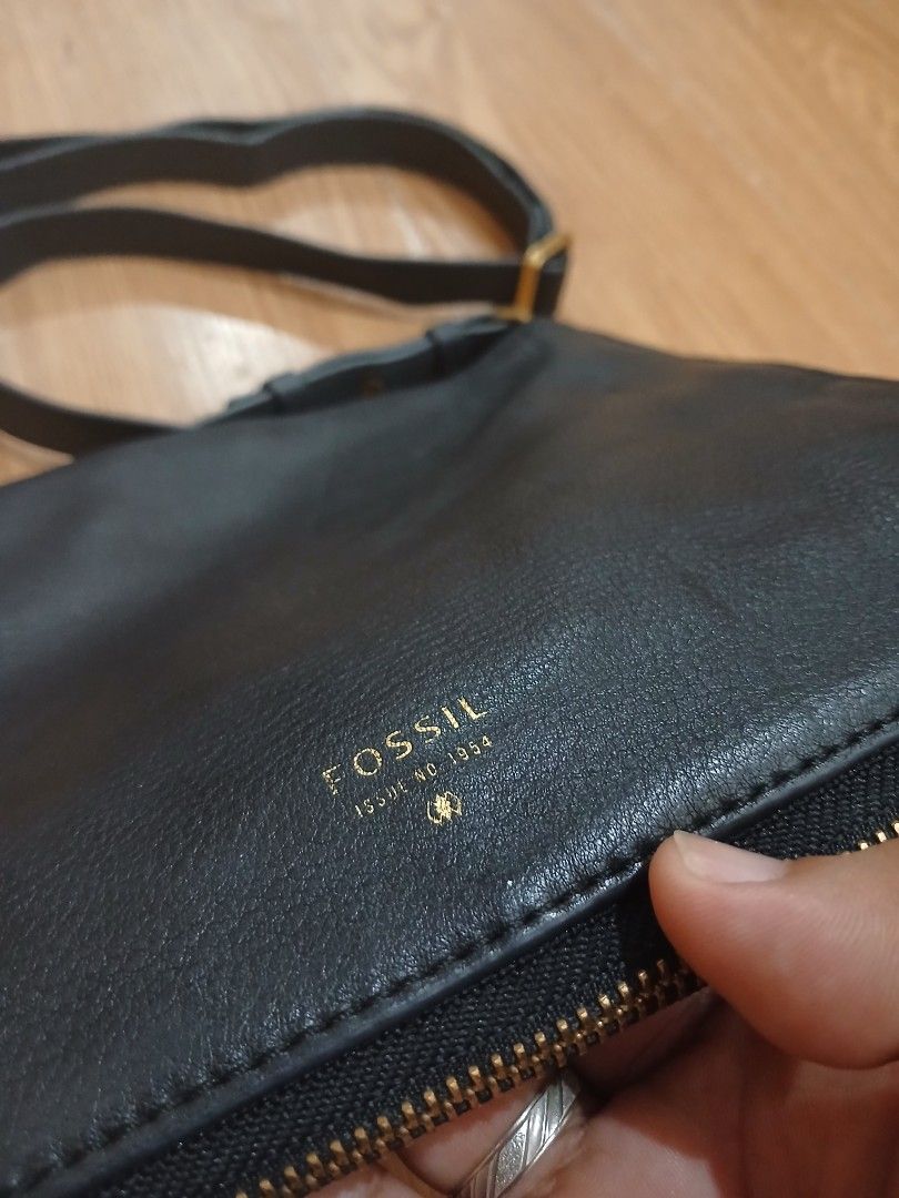 Fossil Black Leather Crossbody Bag (Category: Cross-body Bags) located in Daraga. Submitted by thethriftcity2024 (Listing ID 1465828940, Image 2). Description: - Brand: Fossil - Material: Genuine black pebbled leather - Hardware: Gold-tone with embossed logos - Closure: Top zipper - Strap: Adjustable long shoulder strap - Condition: Clean interior, sturdy zippers, and minor scuffs on the metal pull tabs from regular use.