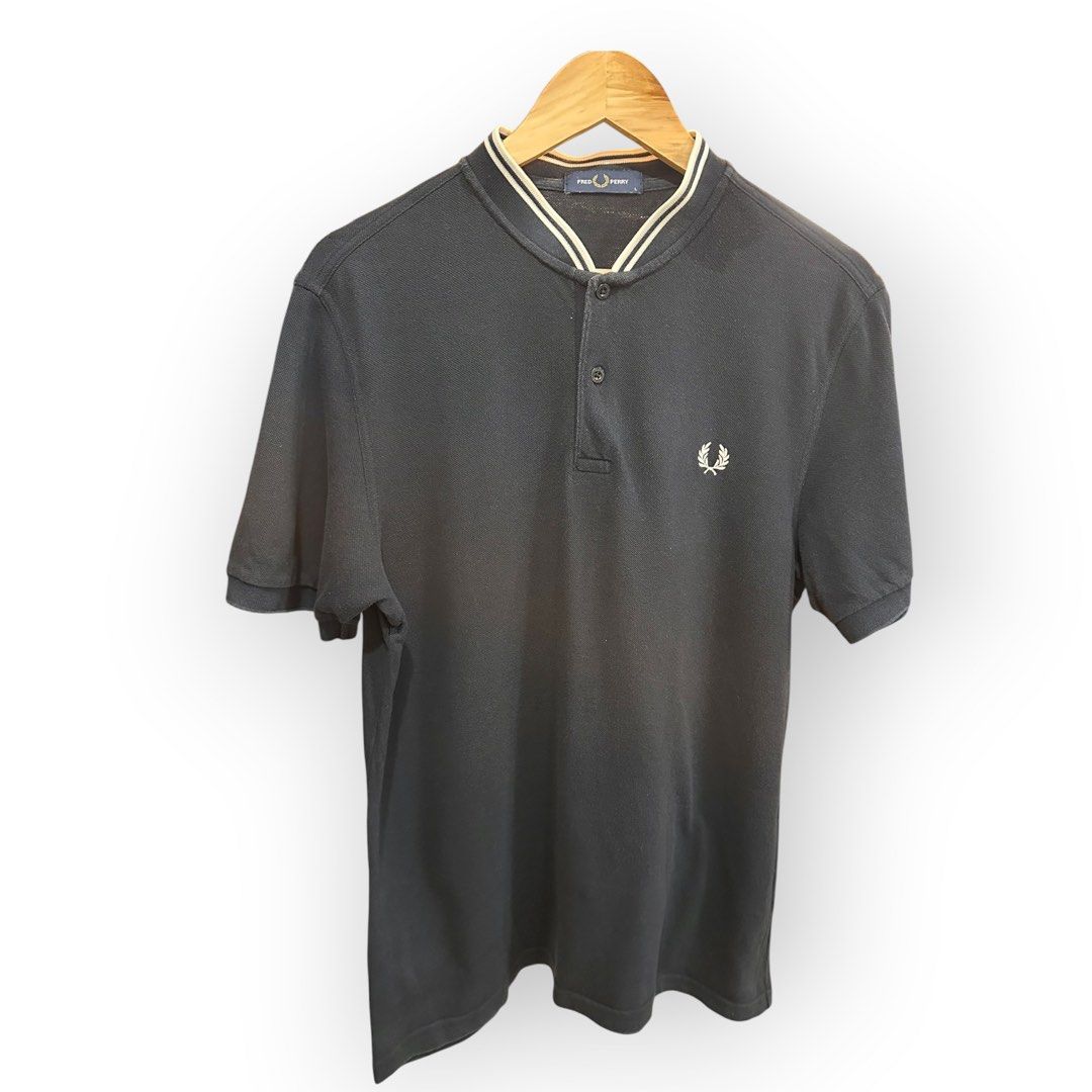 Fred Perry Polo Shirt (Category: Tshirts & Polo Shirts ) located in Bulacan. Submitted by adoseofluxxee (Listing ID 1465763109, Image 1). Description: - Brand: Fred Perry - Color: Dark Navy Blue - Size: L - Material: 100% Cotton (Made in China) - Design: Ribbed collar with striped tipping, two-button placket, and signature embroidered laurel wreath logo on the chest - Condition: Excellent casual wear staple.