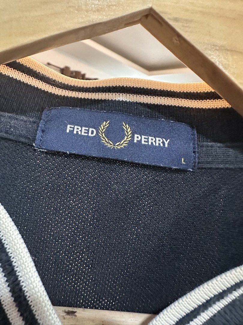 Fred Perry Polo Shirt (Category: Tshirts & Polo Shirts ) located in Bulacan. Submitted by adoseofluxxee (Listing ID 1465763109, Image 2). Description: - Brand: Fred Perry - Color: Dark Navy Blue - Size: L - Material: 100% Cotton (Made in China) - Design: Ribbed collar with striped tipping, two-button placket, and signature embroidered laurel wreath logo on the chest - Condition: Excellent casual wear staple.