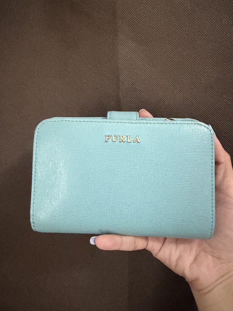 Furla Wallet (Category: Wallets & Card holders) located in Pateros City. Submitted by nightingayle29 (Listing ID 1465768235, Image 1). Description: - Brand: Furla - Color: Light blue with elegant gold hardware - Material: Durable Saffiano leather texture - Closure: Secure snap and smooth zip-around action - Interior: Divided compartments and multiple card slots - Condition: like new - Size: Medium - no inclusion.