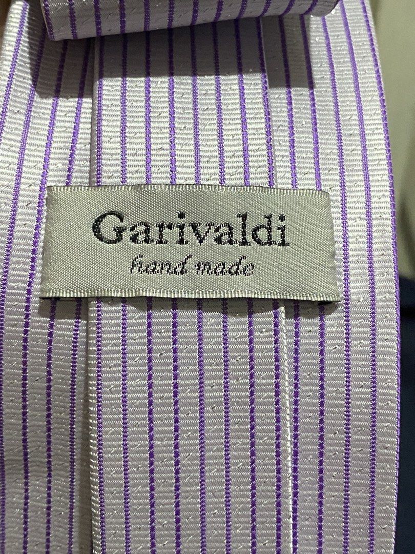 Garivaldi Hand Made Purple Striped Microfiber Tie (Category: Ties) located in Manila. Submitted by resi.diaz (Listing ID 1465894696, Image 3). Description: - Brand: Garivaldi - Color: Light purple with dark purple stripes - Material: 100% microfiber for a clean fabric texture with a subtle woven pattern - Craftsmanship: Hand-made construction quality - Design: Standard width blade with a classic pointed tip - Style: Perfect professional office we