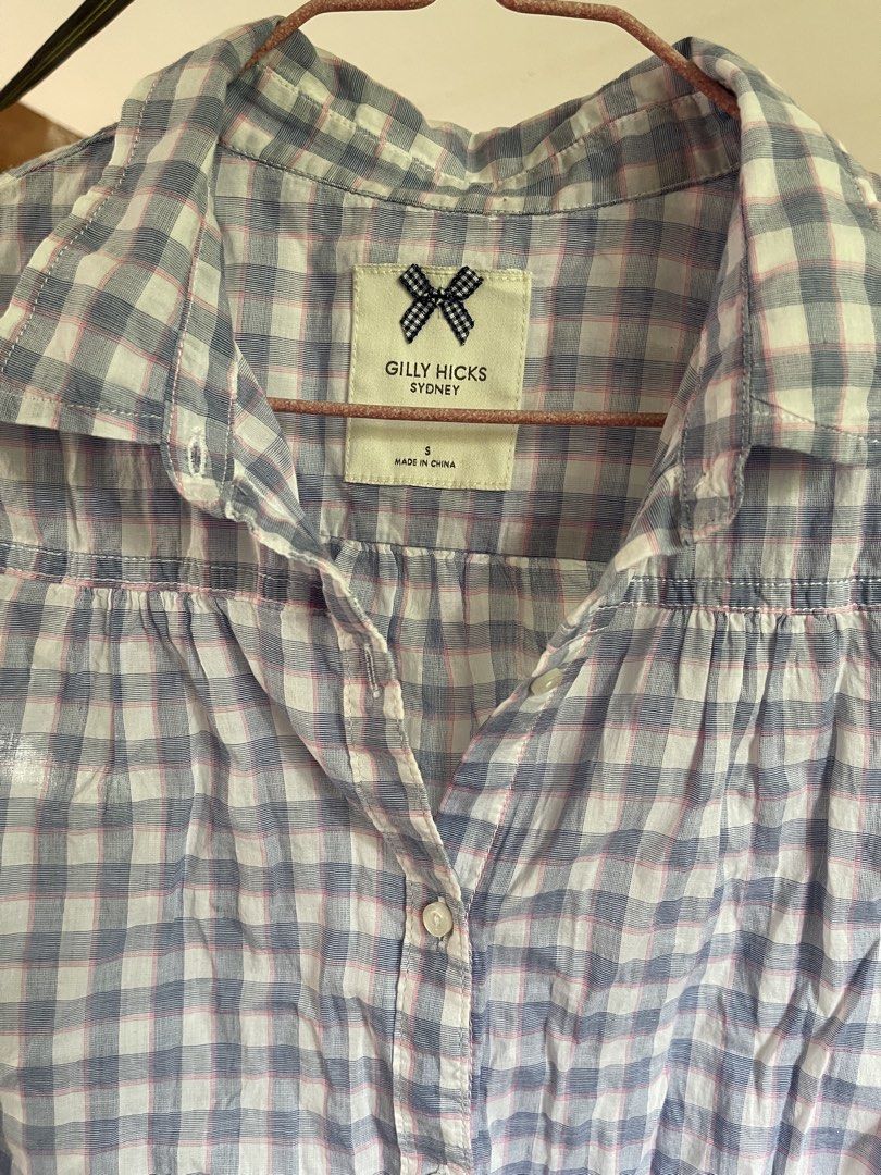 Gilly Hicks Sydney Blue White Gingham Sleeveless Button Up (Category: Sleeveless) located in Baybay. Submitted by shikita27906 (Listing ID 1465848779, Image 2). Description: - Brand: Gilly Hicks Sydney - Size: S - Design: Blue and white gingham with subtle pink grid lines - Style: Sleeveless, classic collar, front button closure - Material: Lightweight cotton - Condition: Great warm weather staple.