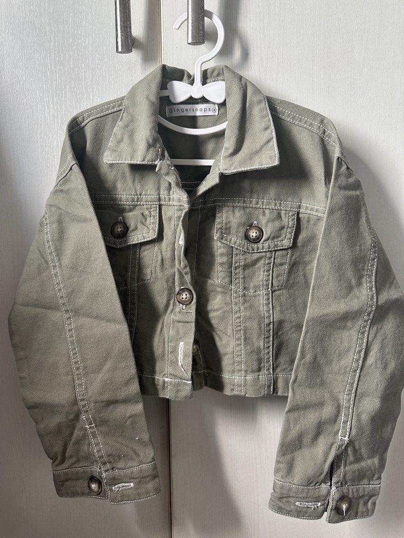 Gingersnaps Green Cropped Jacket Size 4 (Category: Babies & Kids Fashion) located in Quezon City. Submitted by maricrisdiokno (Listing ID 1465828199, Image 1). Description: - Brand: Gingersnaps - Size: 4 - Color: Green with white contrast stitching - Material: Sturdy cotton fabric - Features: Button-up front, collar, and chest pockets - Back Details: Cute embroidered parrot graphic and pink text accent - Condition: Great statement piece for kids.