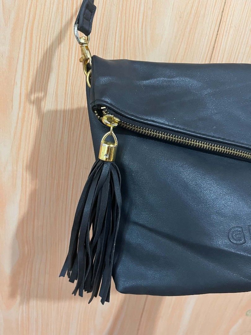 Givenchy Black Crossbody Bag with Tassel (Category: Cross-body Bags) located in Daraga. Submitted by thethriftcity2024 (Listing ID 1465829729, Image 3). Description: - Brand: Givenchy - Color: Classic Black - Design: Foldover style with diagonal front zipper and hanging tassel - Branding: Embossed logo lettering and signature four-G emblem - Hardware: Gold-tone with an adjustable strap - Closure: Secure magnetic snap closures - Interior: Dark lin