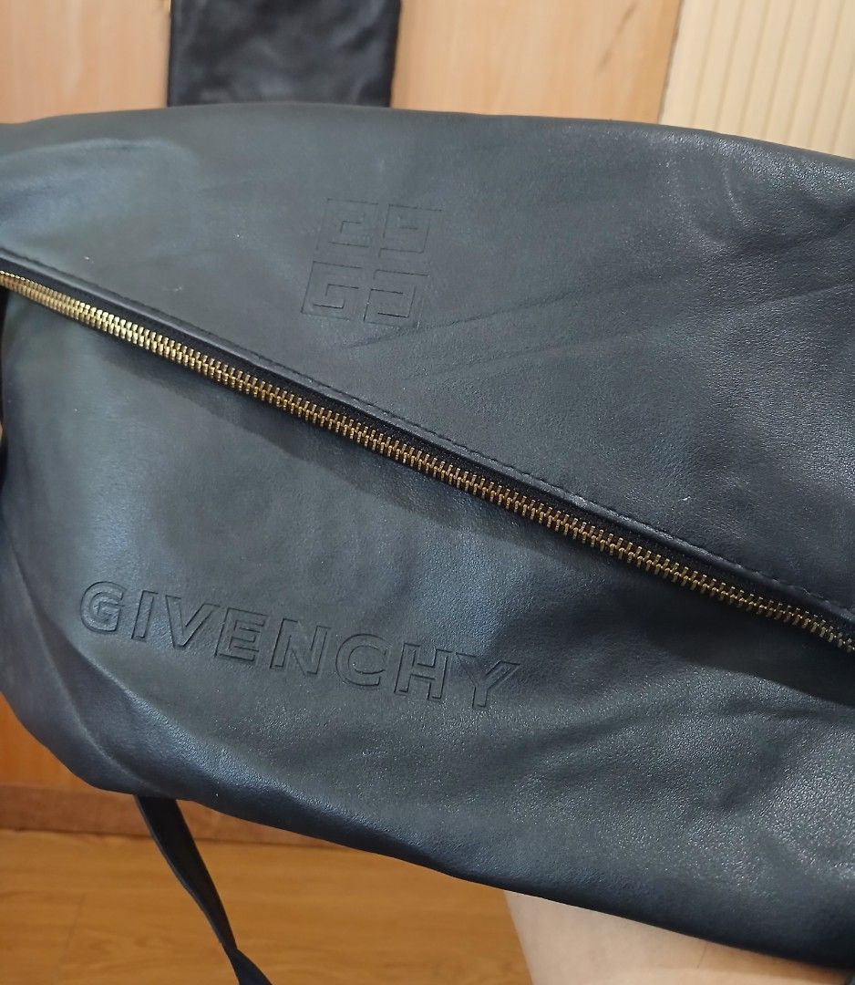 Givenchy Black Crossbody Bag with Tassel (Category: Cross-body Bags) located in Daraga. Submitted by thethriftcity2024 (Listing ID 1465829729, Image 2). Description: - Brand: Givenchy - Color: Classic Black - Design: Foldover style with diagonal front zipper and hanging tassel - Branding: Embossed logo lettering and signature four-G emblem - Hardware: Gold-tone with an adjustable strap - Closure: Secure magnetic snap closures - Interior: Dark lin