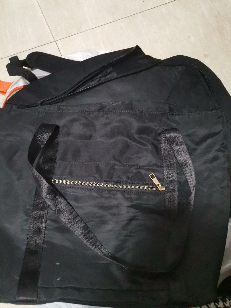 Grab Black Nylon Tote Bag (Category: Tote Bags) located in Makati City. Submitted by kookybearsstuff (Listing ID 1465825706, Image 1). Description: - Color: Black - Material: Lightweight, foldable nylon - Closure: Secure top zip - Pockets: Front zipper pocket and separate interior zip pocket - Details: Features an official Grab branded cloth patch - Usage: Perfect size for everyday errands or extra gear.