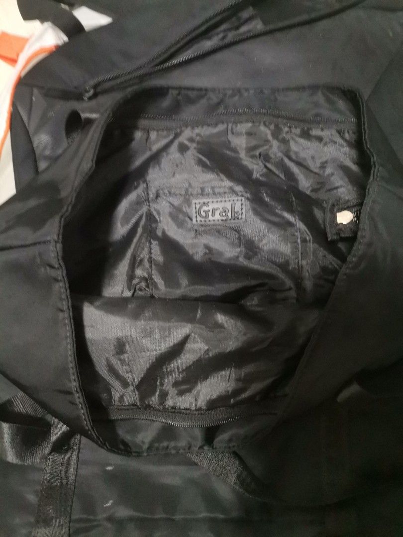 Grab Black Nylon Tote Bag (Category: Tote Bags) located in Makati City. Submitted by kookybearsstuff (Listing ID 1465825706, Image 2). Description: - Color: Black - Material: Lightweight, foldable nylon - Closure: Secure top zip - Pockets: Front zipper pocket and separate interior zip pocket - Details: Features an official Grab branded cloth patch - Usage: Perfect size for everyday errands or extra gear.