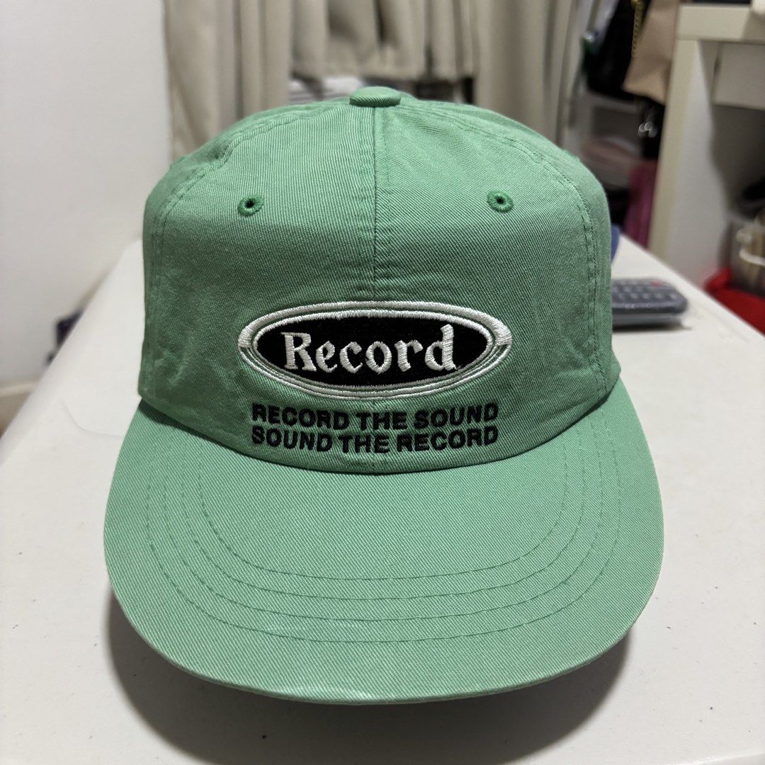Green Camp Hat (Category: Caps & Hats) located in Quezon City. Submitted by grailph (Listing ID 1465882417, Image 1). Description: - Brand/Collab: The Moment x Unisex Market - Design: Green 6-panel cap with "Record" embroidered front patch - Size: M (with adjustable strap and silver metal clasp) - Details: Embroidered eyelets for breathability - Condition: Excellent/Ready to wear Color rate 7/10 Even fade.