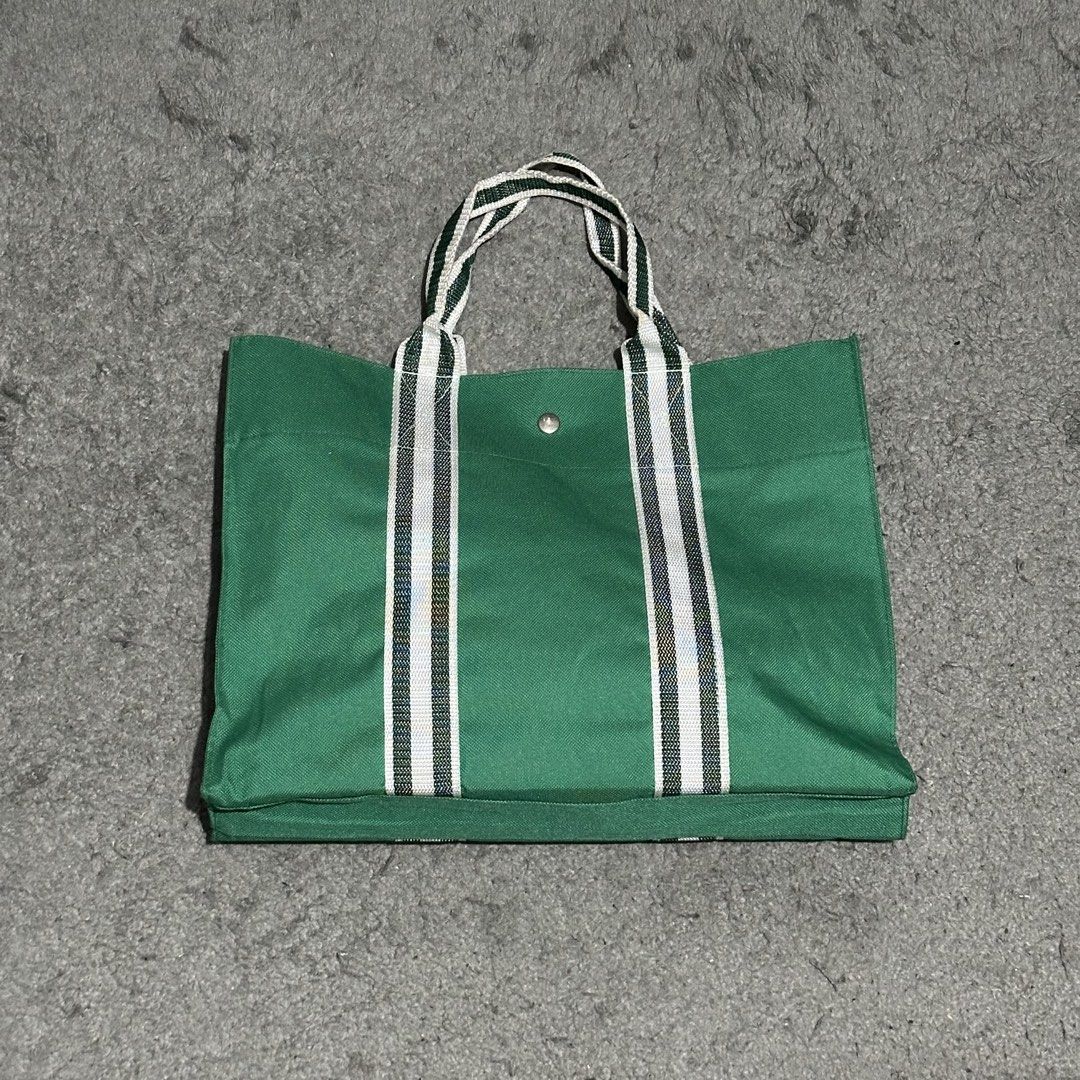 Green Canvas Tote Bag with Brook Graphic (Category: Tote Bags) located in Lipa City. Submitted by jecoparra (Listing ID 1465842617, Image 3). Description: - Green canvas tote bag with One Piece Brook graphic - Secure top snap button closure - Durable green and white double-striped handles - Structured rectangular bottom for better support - Clean fabric, ideal for books and daily essentials.