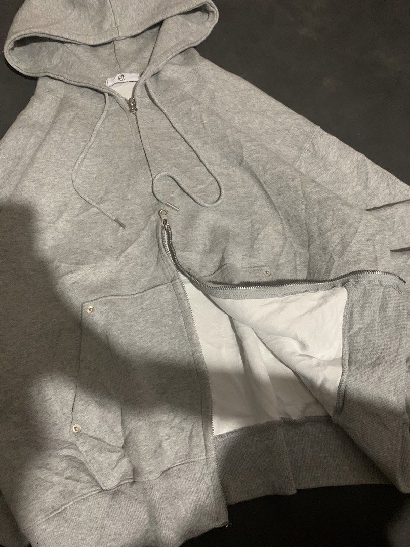 Grey Zip-Up Hoodie with Double-Sided Pockets (Category: Coats, Jackets and Outerwear) located in Valencia. Submitted by davehandpicked (Listing ID 1465893041, Image 2). Description: - Color: Grey - Fit: Oversized relaxed fit - Material: Soft cotton blend with clean white interior lining - Hardware: Premium dual-way zipper - Hood: Adjustable drawstring hood - Pockets: Large front pockets with metallic snap buttons.